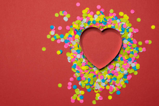 Heart-shaped paper puncher confetti scattered on a red background. Valentine LOVE concept Heart-shaped paper puncher confetti scattered on a red background. Valentine LOVE concept. hole puncher stock pictures, royalty-free photos & images