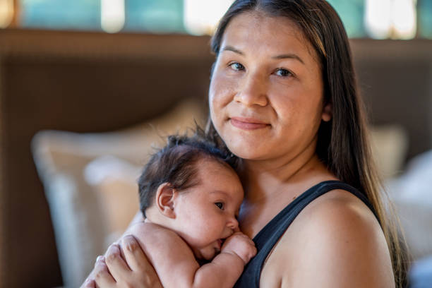 Mother and baby portrait A woman holds her baby happily in her home. american tribal culture stock pictures, royalty-free photos & images