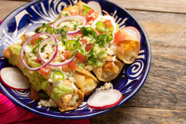 istock Mexican fried potato tacos called flautas with guacamole and cheese 1364505479