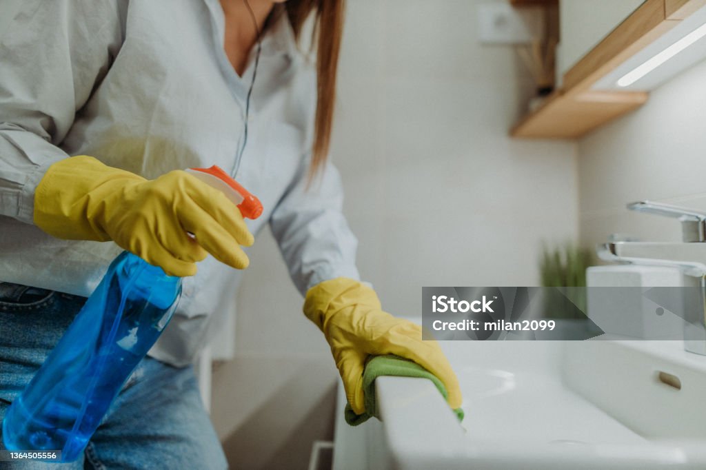Cleaning time Young woman dusting Cleaning Stock Photo