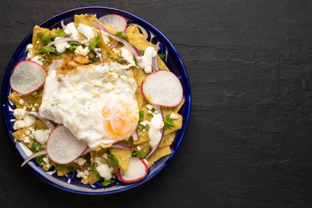 Mexican green chilaquiles with fried egg and cheese Traditional mexican green chilaquiles with fried egg and cheese tomatillo photos stock pictures, royalty-free photos & images