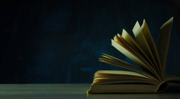 istock Open book, hardback book on wooden table on dark background. Back to school,education,reading. Copy space 1364507775