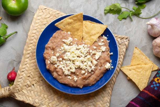 haricots frits mexicains avec fromage et totopos - mash bean photos et images de collection