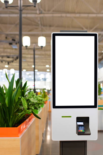 istock Self service electronic counter with blank mockups on white screen and payment terminal in fast food restaurant, shopping mall 1364515890