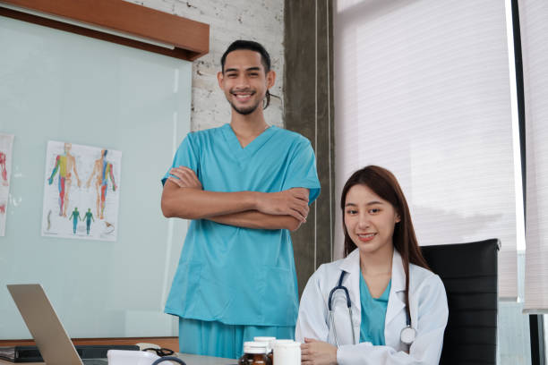 istock Smile uniform two young doctors team with stethoscope in clinic. 1364517776