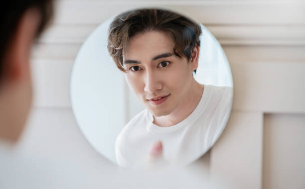 istock Closeup portrait of handsome beautiful asian boy with mirror makeup routine with copy space. Beauty influencer guy with perfect glow skin dress up. Healthcare man lifestyle cosmetic blogger concept 1364523649