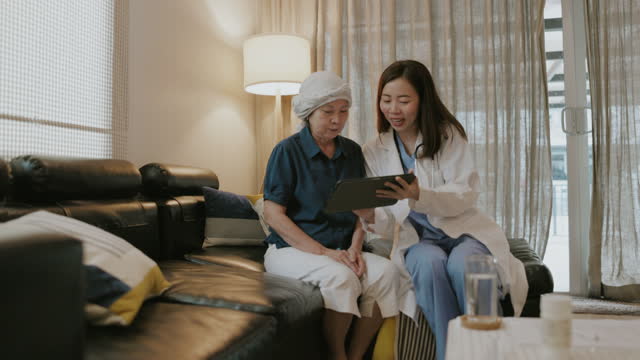 Smiling Asian senior patient and female doctor with home healthcare service-stock video