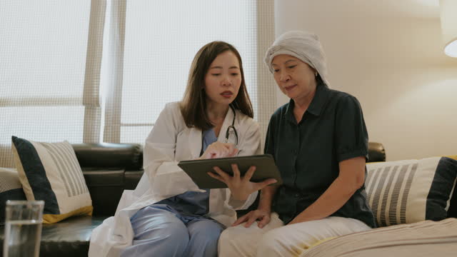 Southeast Asian senior woman with cancer meeting with female physician stock video