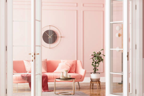 entrance of living room with pink sofa, potted plant and coffee table - fotos de aconchegante imagens e fotografias de stock