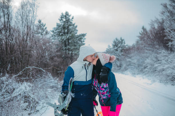 istock Young couple is kissing in a winter forest 1364529069