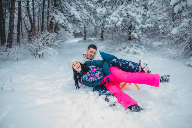 istock A happy couple enjoys a cold winter day while falling off a sled 1364530589
