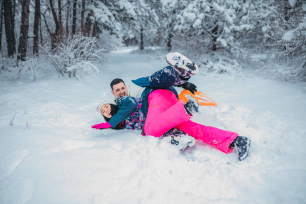 istock A happy couple enjoys a cold winter day while falling off a sled 1364530596