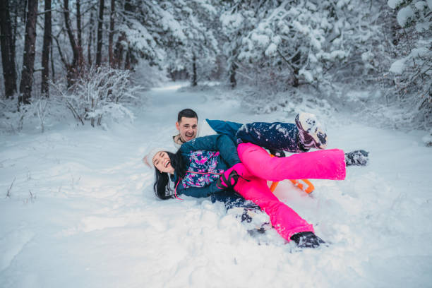 istock A happy couple enjoys a cold winter day while falling off a sled 1364530599