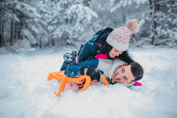istock A happy couple enjoys a cold winter day while falling off a sled 1364530670