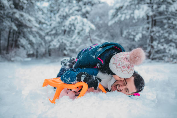 istock A happy couple enjoys a cold winter day while falling off a sled 1364530676