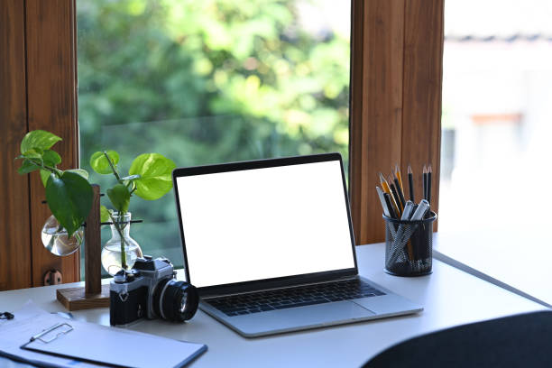 istock Mock up computer laptop, camera, pencil holder and houseplant on white table. 1364531534