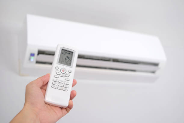 istock Man's hand using remote control open The air conditioner is cooled to 25 degrees Celsius in his bedroom. Health concepts and energy savings 1364536431