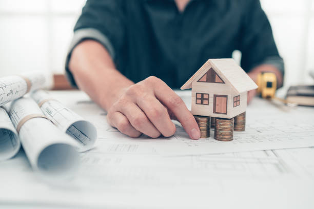 istock Mini model house, Money, pencil, compass  and roll blueprint plan  on blueprint house plan design. Cost Architect and engineer concept. 1364536436