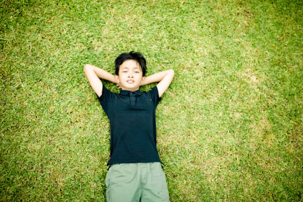 istock high angle view little boy lying on grass in nature 1364537740