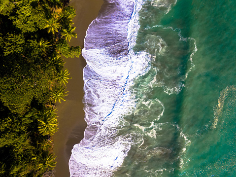 Aerial view from  spectacular beach by the Pacific Ocean with lush tropical rainforest in the Osa Peninsula of Costa Rica, Corcovado National Park.