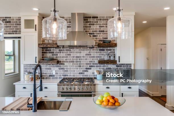 Gorgeous Kitchen With Vent Hood And Brick Backsplash Stock Photo - Download Image Now