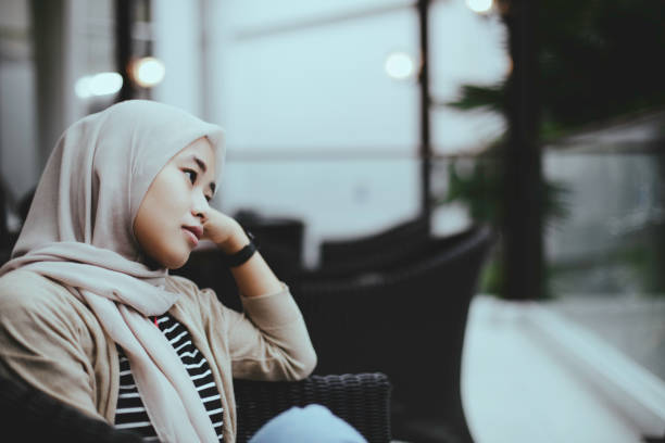 tristeza muçulmano mulher sentado na cadeira - confusion hand in hair tired touching - fotografias e filmes do acervo