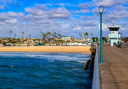 Pacific ocean waves at the beach in a famous tourist destination viewed from Seal Beach pier in California, USA