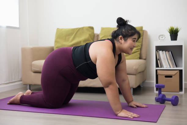 istock Young asian sport woman plus size sitting practicing yoga lesson. Stretching  training workout on yoga mat at home for good health and body shape. 1364543933