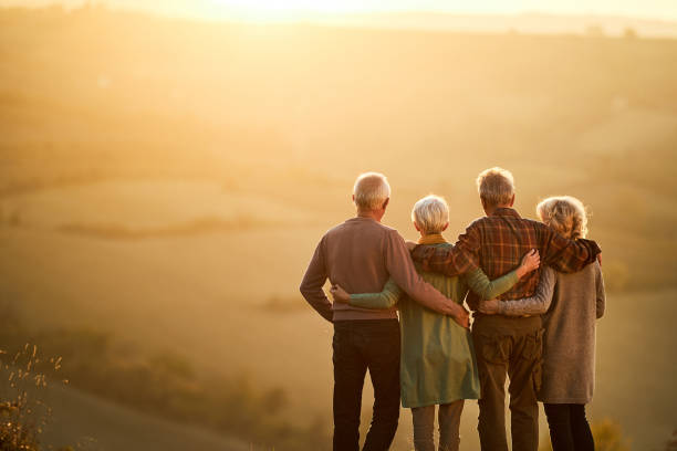 istock Back view of embraced seniors looking at sunset view from a hill. 1364545947
