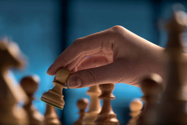 istock Chess game tournament: the player is moving a pawn 1364546864