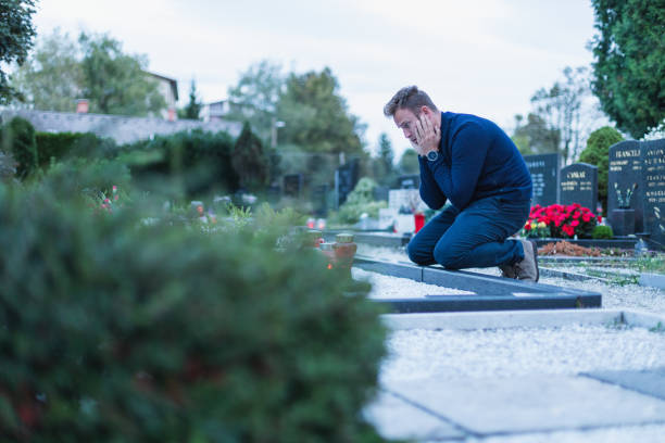istock Man crying at the cementery, sad 1364546879