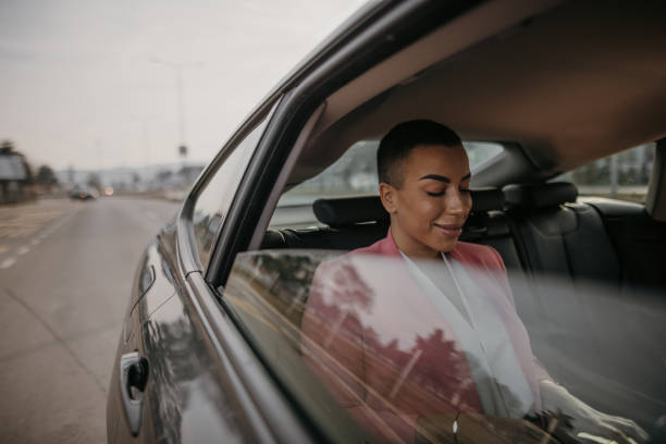istock Short haired woman sitting on back seat in car 1364546971