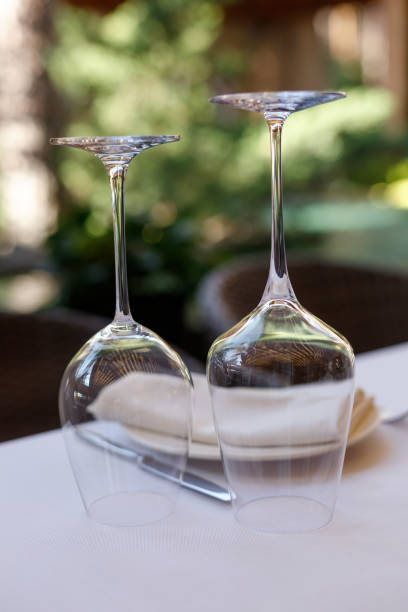 istock Table setting in restaurant terrace outdoor. Inverted upside down wine glasses on a table on a white tablecloth. 1364552837