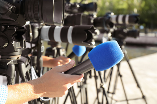 Periodistas con micrófonos y cámaras de video al aire libre, primer plano photo