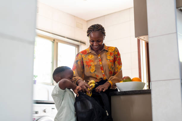 istock Mother helps son pack bananas into schoolbag 1364555176