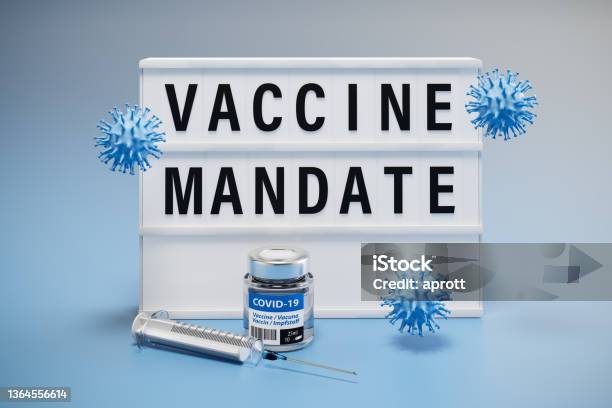 The Words Vaccine Mandate Displayed On A Lightbox Syringe Virus Models And A Bottle Of Vaccine Around Stock Photo - Download Image Now