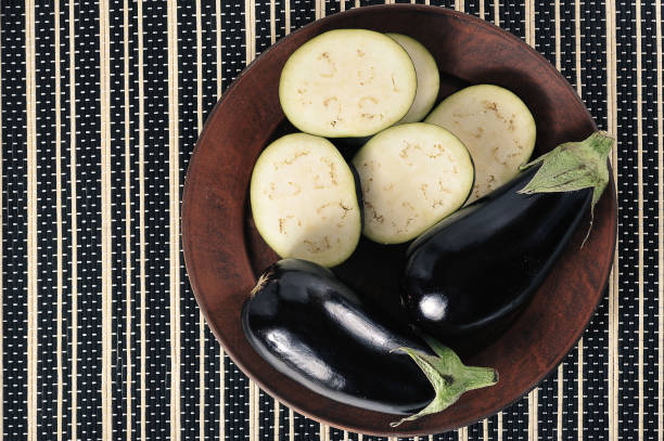 istock whole eggplants and sliced eggplants on a plate - top view 1364561556