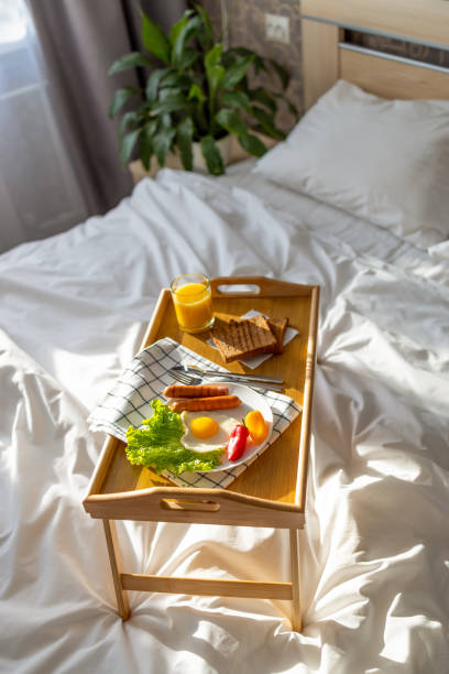 istock Breakfast on a tray in bed. Morning. Fried eggs in the shape of a heart with vegetables. 1364561663