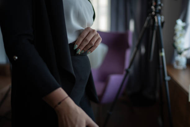 Close up of well dressed woman's torso while standing in apartment