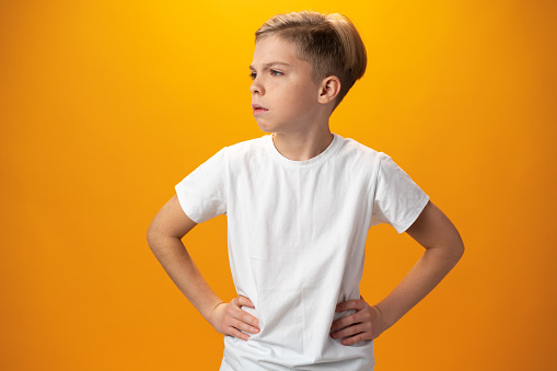 Portrait of naughty little boy against yellow background, close up