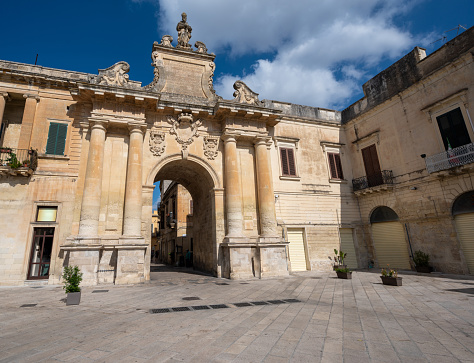Lecce, Puglia, Italy. August 2021. View towards one of the access gates to the historic center. People enter and leave the old city through it. Beautiful summer day.