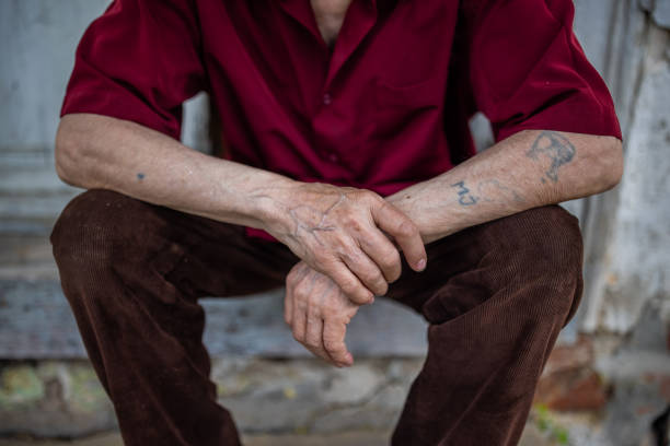 Close up of the unrecognizable senior man and his tattooed hands