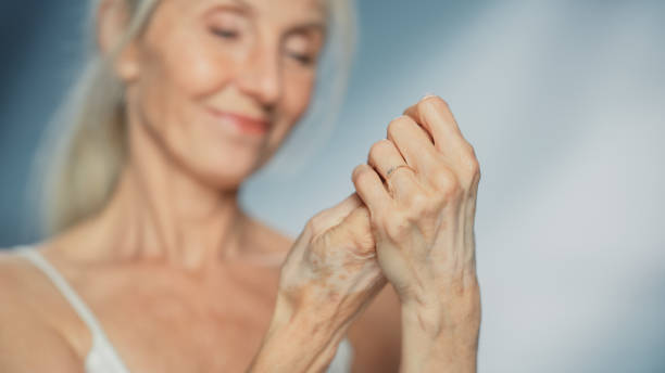 portrait of beautiful senior woman using hand mosturizing cream. elderly lady makes her skin soft, smooth, wrinkle free with natural anti-aging cosmetics. product for beauty skincare in sensual shot - 潤手霜 個照片及圖片檔