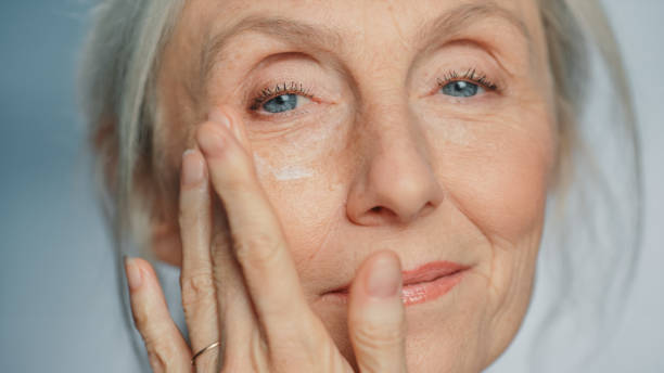 Portrait of Beautiful Senior Woman Gently Applying Under Eye Face Cream. Elderly Lady Makes Her Skin Soft, Smooth, Wrinkle Free with Natural anti-aging Cosmetics. Product for Beauty Skincare, Makeup Portrait of Beautiful Senior Woman Gently Applying Under Eye Face Cream. Elderly Lady Makes Her Skin Soft, Smooth, Wrinkle Free with Natural anti-aging Cosmetics. Product for Beauty Skincare, Makeup cheek photos stock pictures, royalty-free photos & images