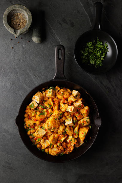 gesundes veganes blumenkohl-, kichererbsen- und tofu-curry - dieting front view vertical lifestyles stock-fotos und bilder