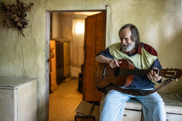 istock Poor senior man playing acoustic guitar 1364569212