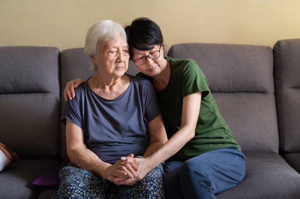 Asian daughter spending time with her elderly mother at home Mature Asian woman spending quality time with her depressed elderly mother at home. asian dementia stock pictures, royalty-free photos & images