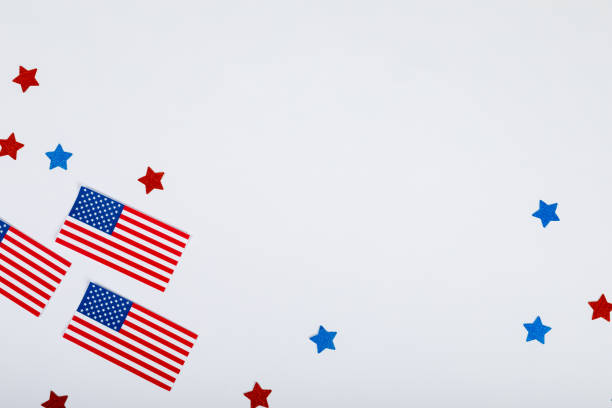 istock Overhead view of usa flags by scattered star glitters with copy space on white background 1364570838