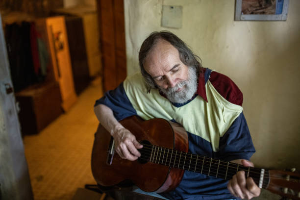 istock At his modest home, senior man playing acoustic guitar 1364570849