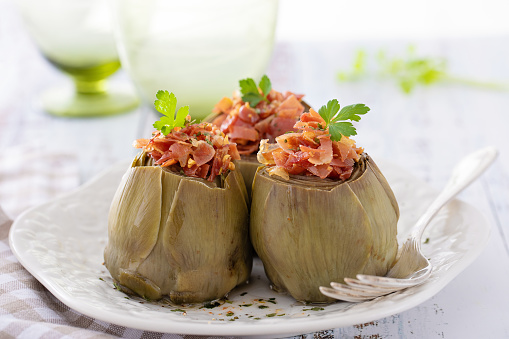 Front view of artichokes with garlic and serrano ham